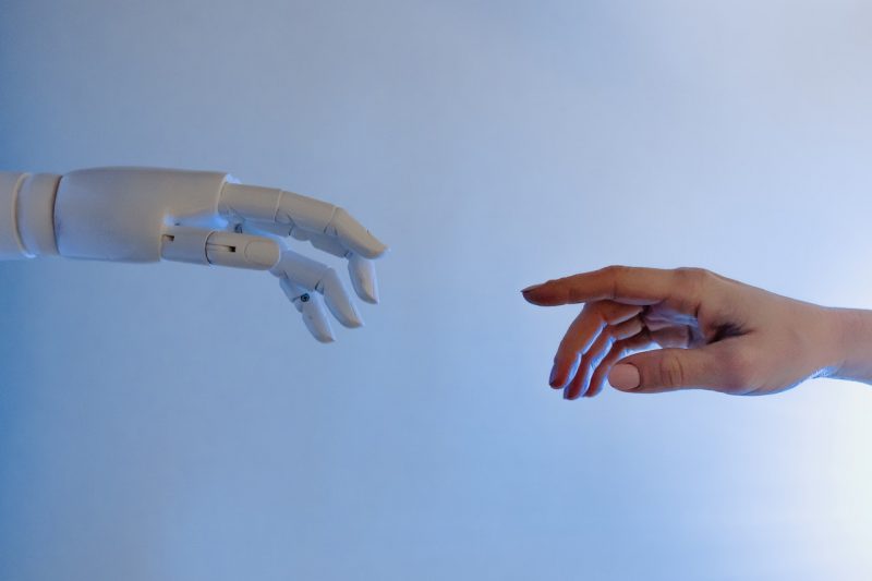 ChatGPT: Robot hand at left reach for human hand at right.