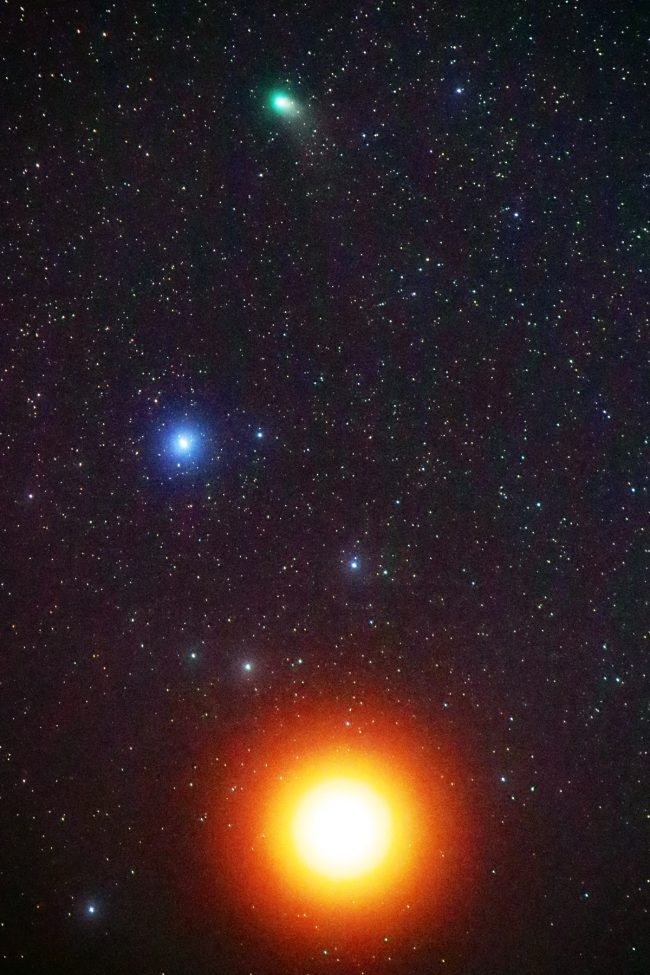 Starry sky with green comet at top, bluish star in middle and overexposed reddish Mars at bottom.