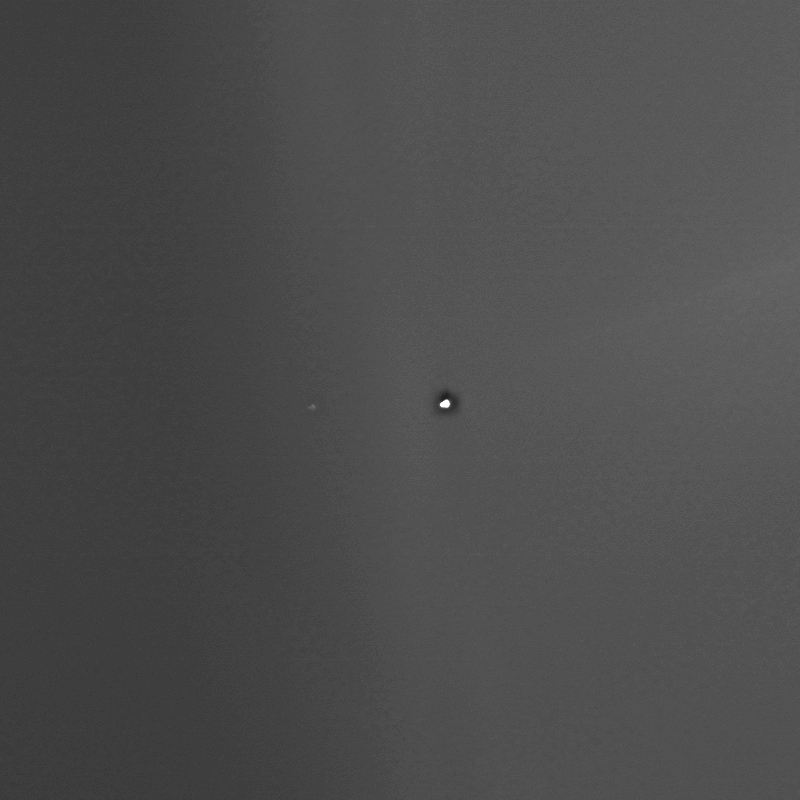 A tiny Earth, and a barely visible orbiting moon, seen from Mars.