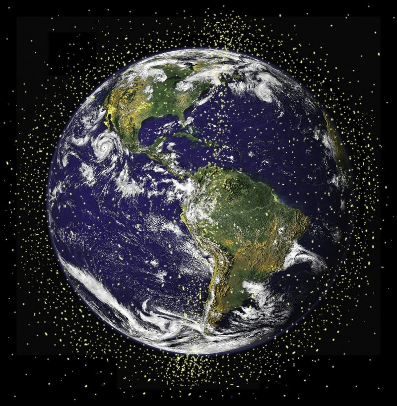 Blue and green globe of Earth surrounded by yellow dots that show possible space junk disaster.