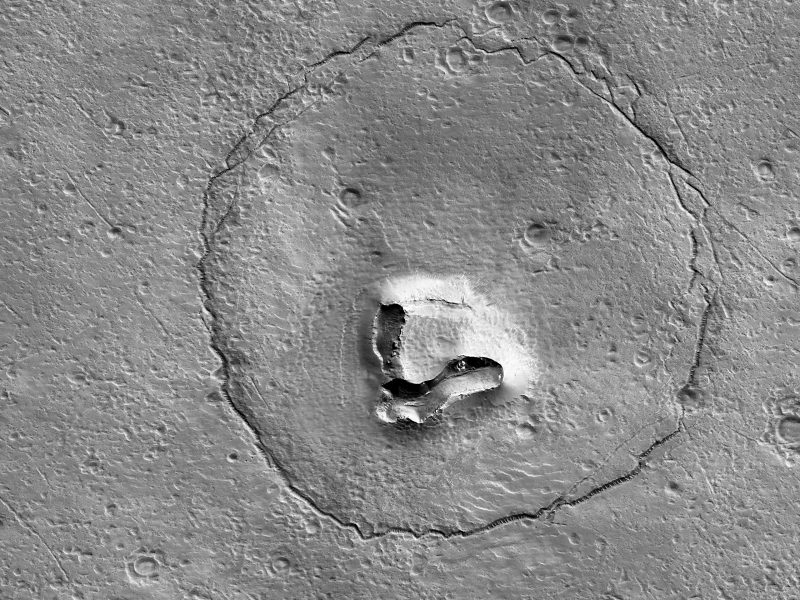 Teddy bear on Mars: Black-and-white surface with round circle, two depressions for 'eyes' and V-shaped formation for 'snout'.