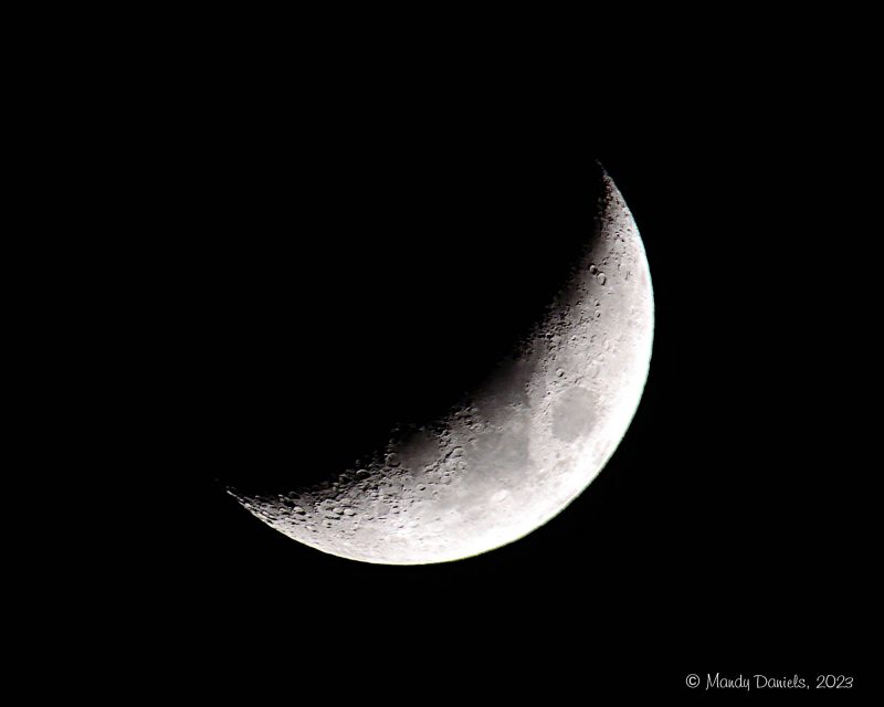 Waxing crescent moon against a dark sky.