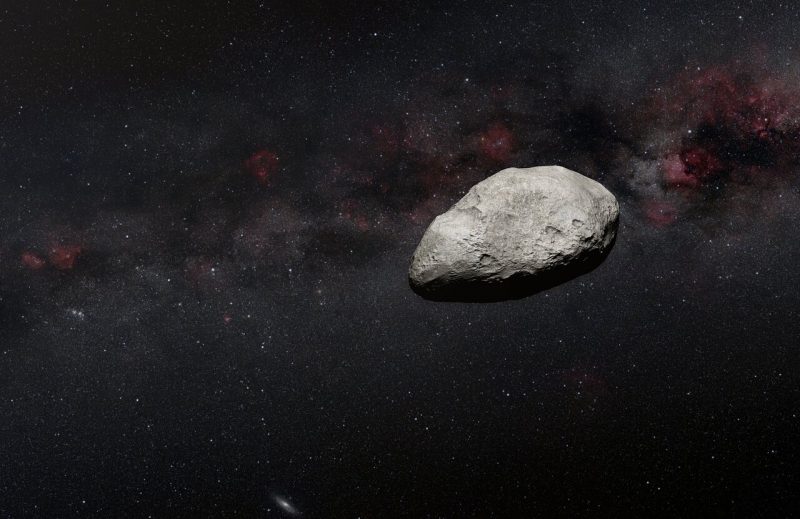 Small potato-shaped gray asteroid, sunlit on one side, with starry background.