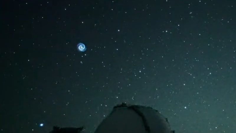 Starry sky with telescope dome and mysteriously spiral of light blue small, high in sky.