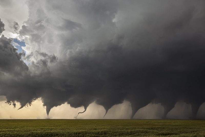 7 images of a tornado from thin funnel cloud to ground-touching tornado surrounded by debris and dust.