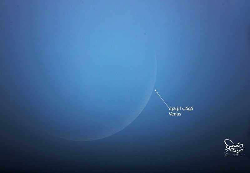 Moon occults Venus in dim image of hazy moon with a bright dot near the limb.
