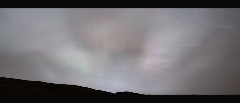Sunrays on Mars: Faint sun rays radiating out from a point on the horizon through gray clouds.