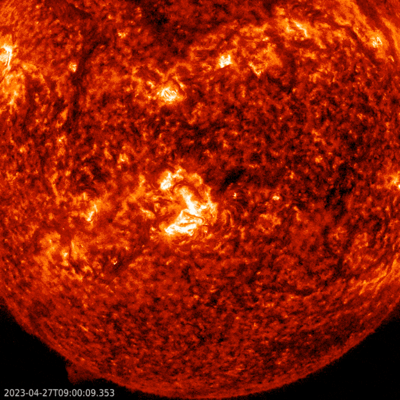 Part of a red globe with a bright flash near center of the image