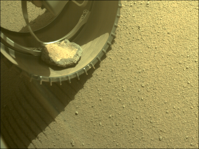 hollow metal wheel gray rock dust pebbles mars rover perseverance loses pet rock.