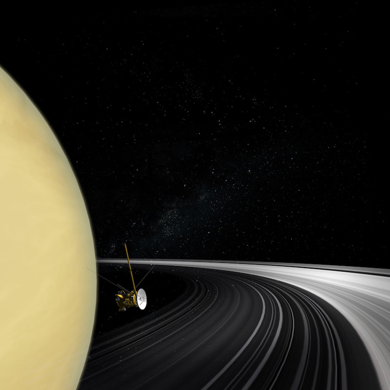 Spacecraft above the curving rings of a giant planet.