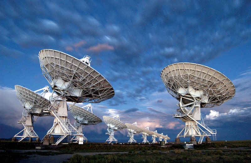 SETI: Group of 10 telescopes under partly cloudy skies.