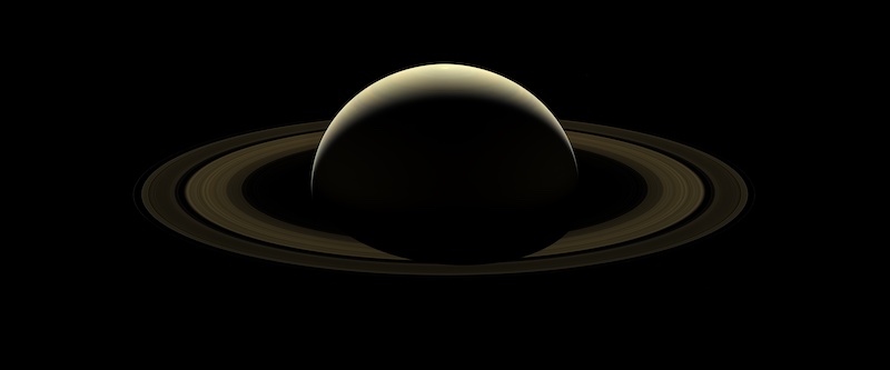 Saturn's rings: Planet mostly in shadow with multiple rings around it.