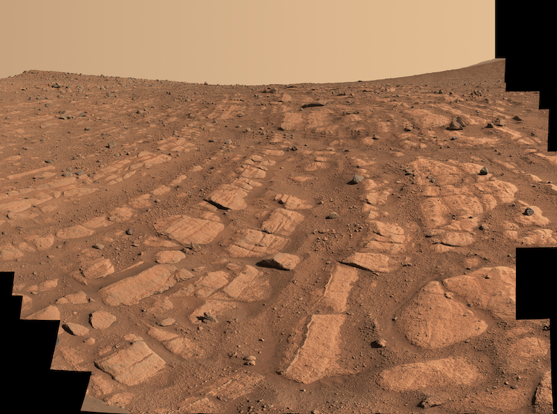 River on Mars: Long, curving lines of reddish rock, with dusty, reddish sky above.