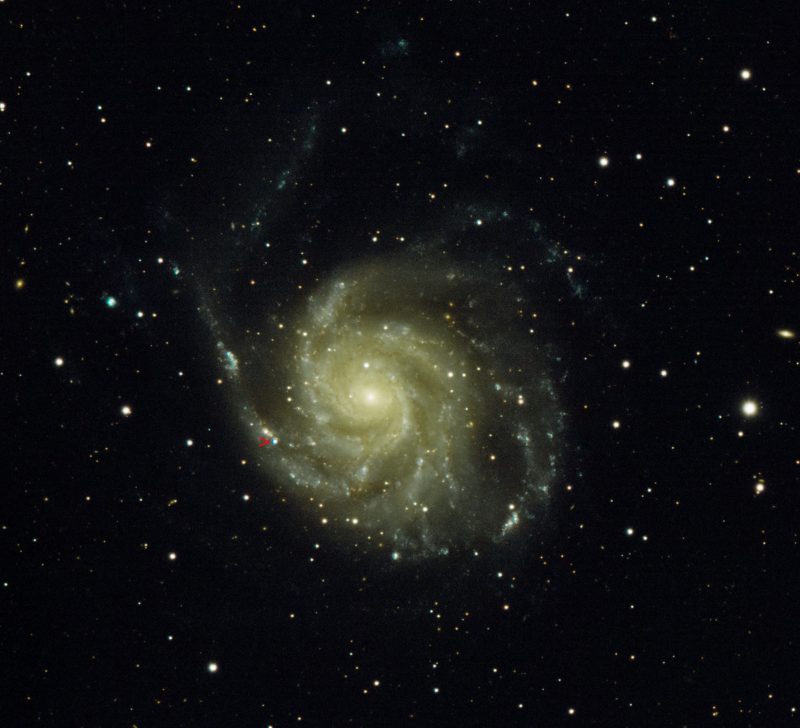 Spiral galaxy with 1 very bright spot in 1 of the arms indicated.