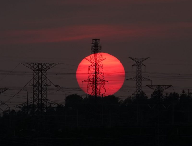 Red suns and moons: A large, very red sun about to dip into the horizon, with electrical masts in the foreground.