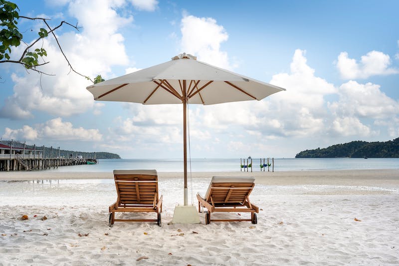 Hottest day: Two lounging chairs on the beach with an umbrella.