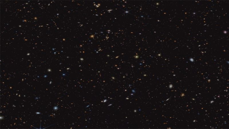 45,000 baby galaxies: Small spirals and irregular shaped spots on a black background.