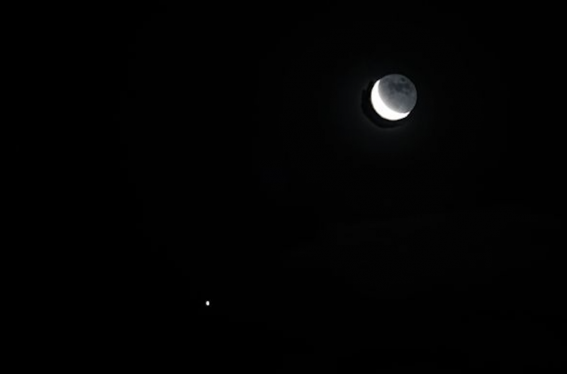 Waning moon at top right and bright planet at bottom left.