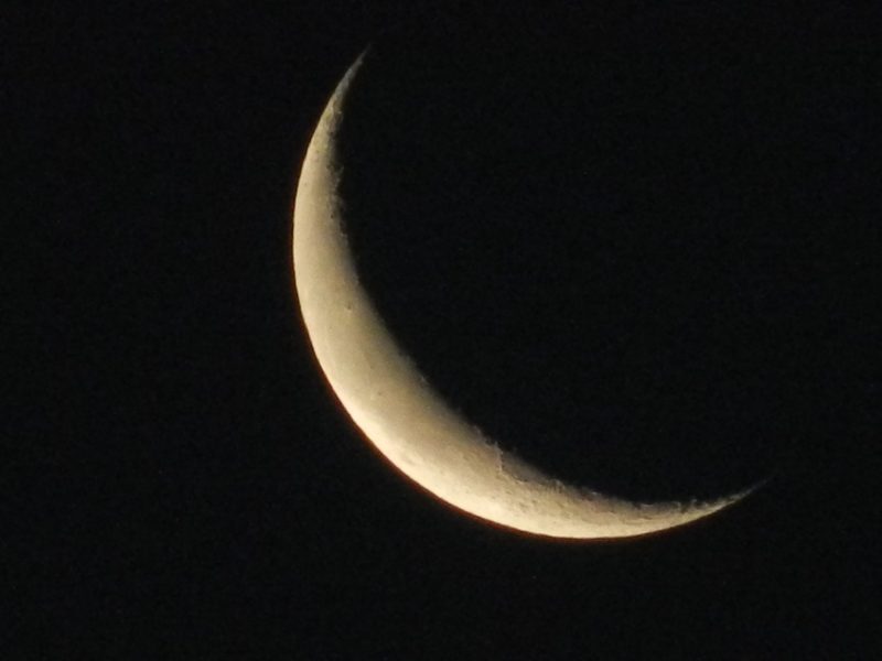 Telescopic image of waning crescent moon.