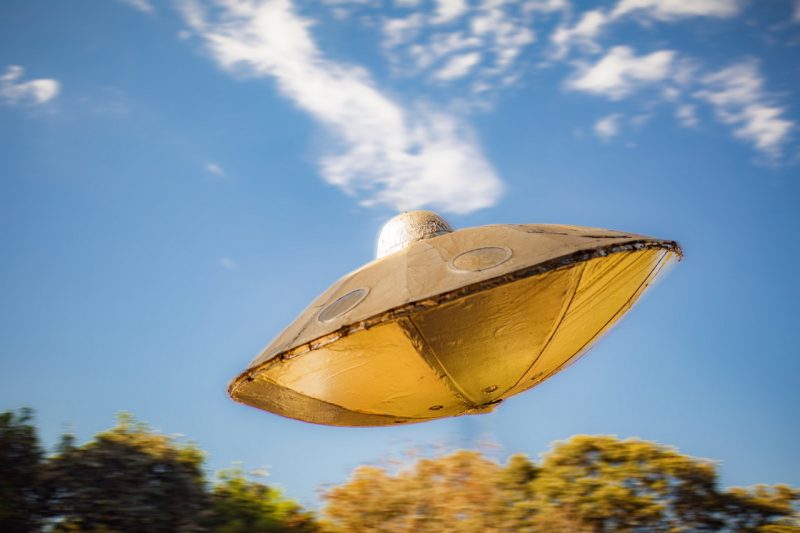 Shiny gold 'flying saucer' against a blue sky.
