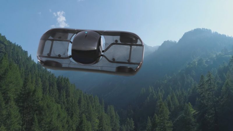 A mostly translucent car-shaped object flying sideways in the sky over steep forested mountains.
