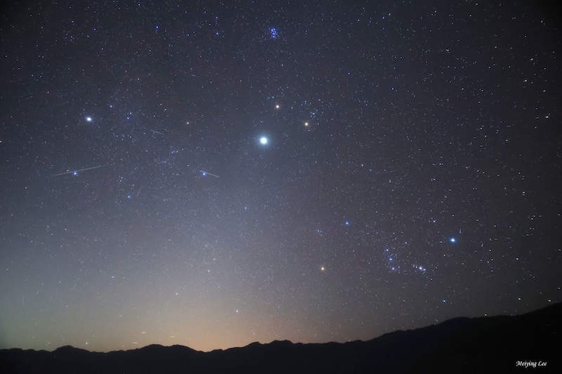 Night sky, with fuzzy column of light from the horizon and many bright dots.