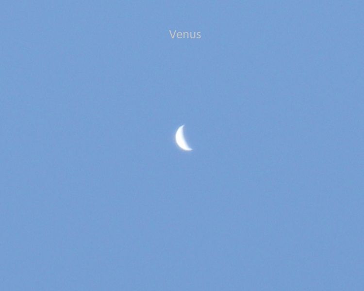 Blue sky with a crescent Venus.