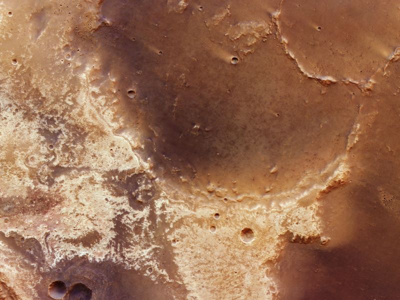 Find life on Mars: View looking down at surface of Mars showing brown, tan and cream landforms.