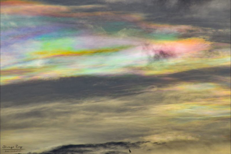 Sky full of clouds with green, orange, yellow, pink, purple and blue colors.