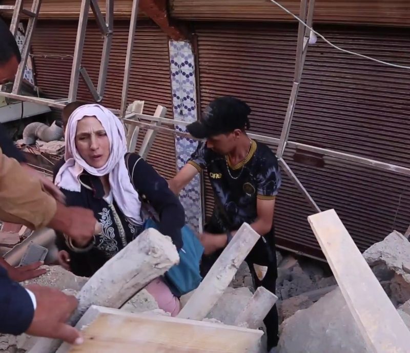 Morocco earthquake aid: Woman and boy, surrounded by earthquake rubble.