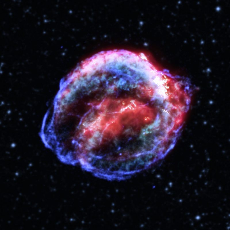 Red and blue concentric spheres of glowing gas against dark starry background.