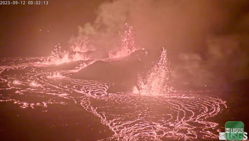 Kilauea is erupting: Copious, glowing lava flow with lava fountaining into the air in the background.