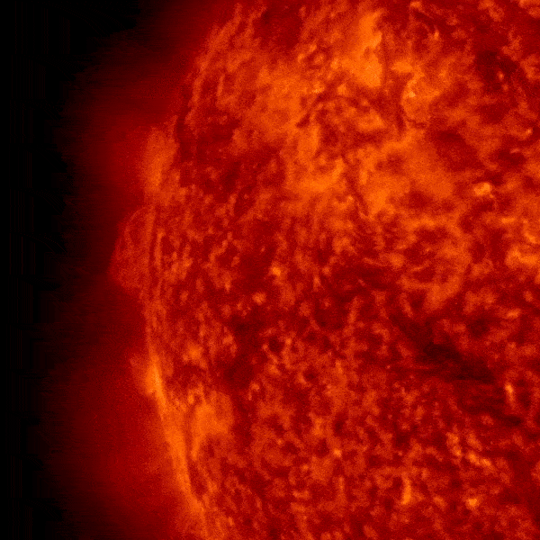 Rotating view of mottled red and orange sun with vast fiery explosions peeking out from behind the edge.