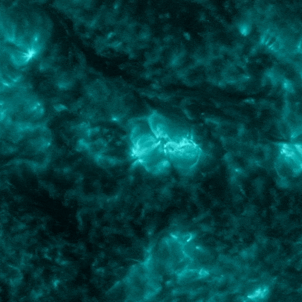 Teal and black mottled surface with brilliant explosion near the center.