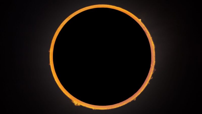 Annular solar eclipse: Orange ring with some little flames coming out ou it.