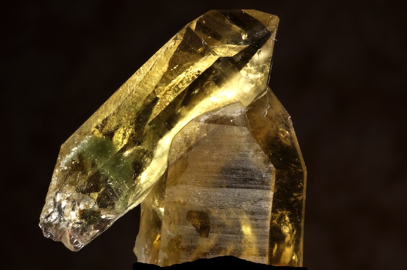 Two pointed, hexagonal natural crystals of a transparent yellow gemstone.