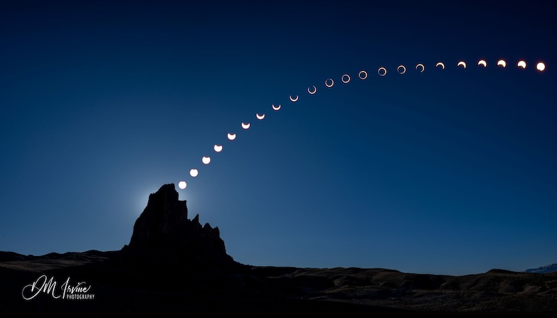 Dark mountain peak against deep blue sky showing line of suns from round to annular and back.