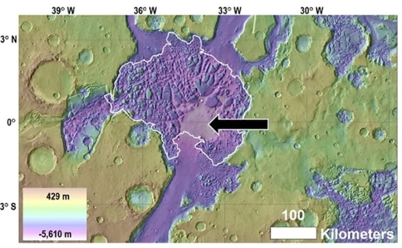 Brownish and blue cratered terrain seen from above with a white outlined area in middle and black arrow.