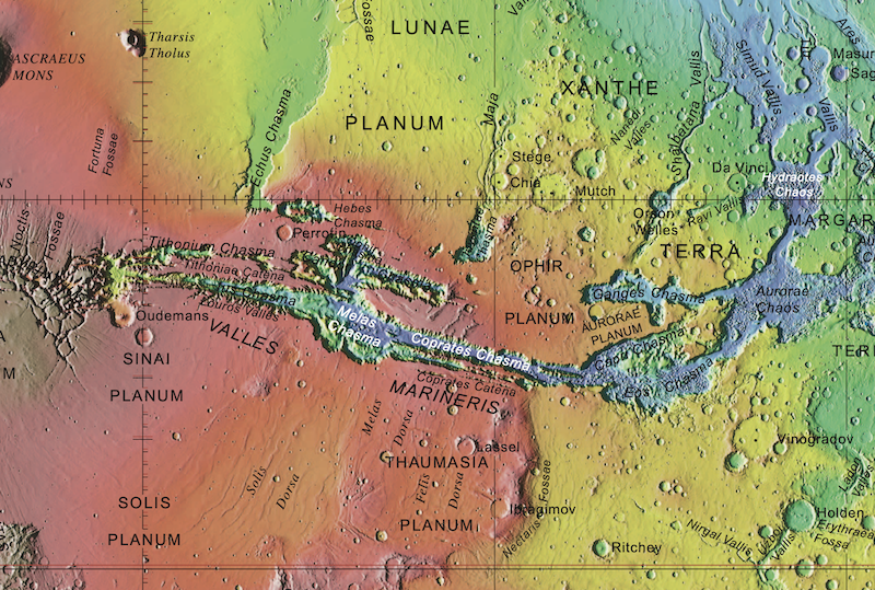 Mud lake on Mars: Red, yellow and blue terrain seen from above, with large fractures and craters and black and white text.