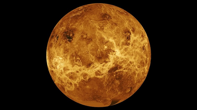 Plate tectonics on Venus: Bright, orange and yellow mottled planet with varied surface texture, on black background.