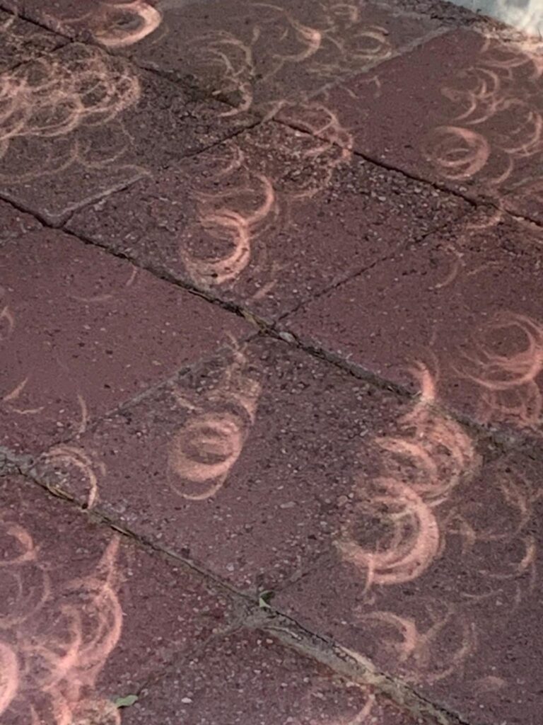 Rings of light on a brick pavement.