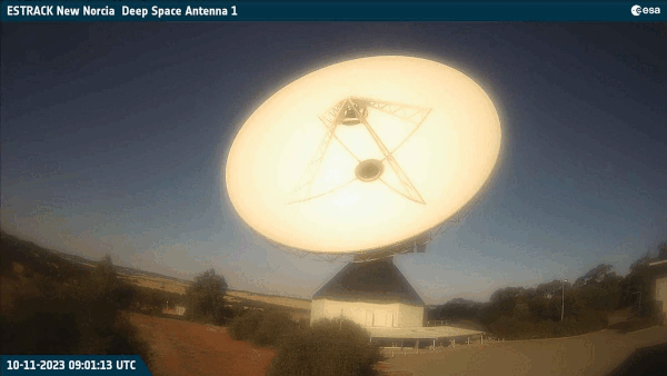 A large white dish telescope, moving, scans a swath of the sky.