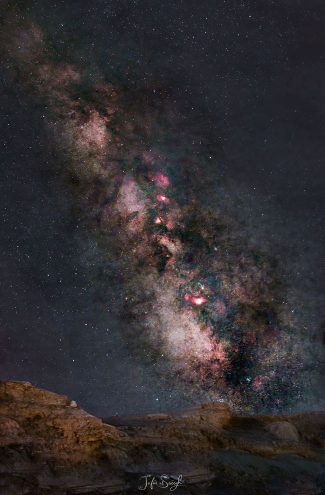 The Milky Way with starry clouds and bright patches along with dark lanes.
