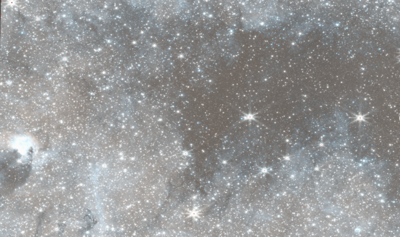 A region of space showing many stars across the whole scene, with the left side lighter in the background and the right side darker.
