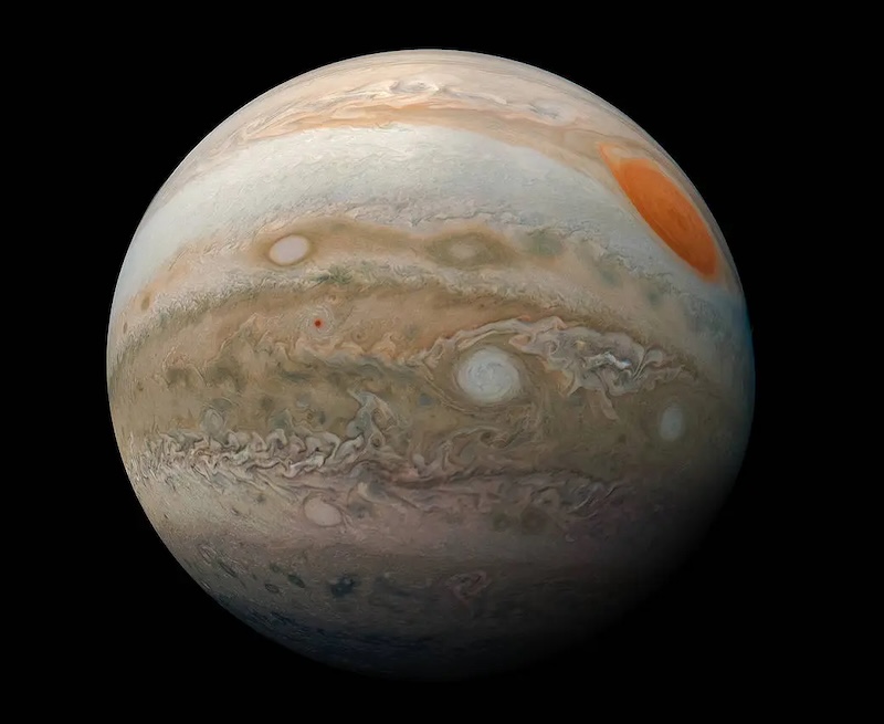 ESPRESSO: Large, brownish planet with banded and spotted atmosphere, on black background. There is a big orange spot on its surface.