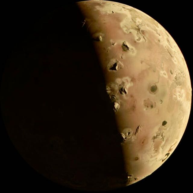 Tan half-sphere with many dark spots plus connecting lighter regions that suggest varied terrain.