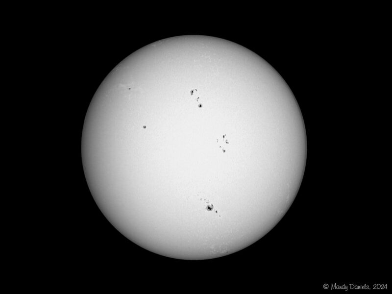 The sun, seen as a large white sphere with dark spots.