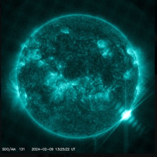 Round globe of sun with X flare in bottom right corner.