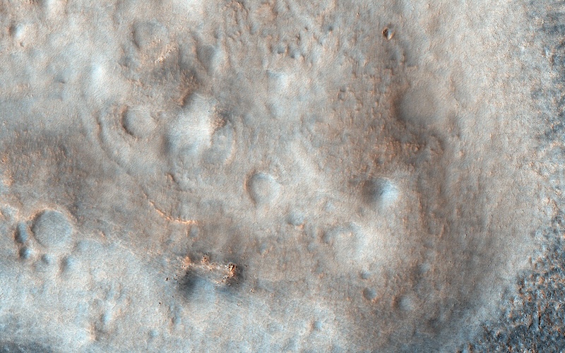 Overhead view of low, lumpy mounds and a few craters.