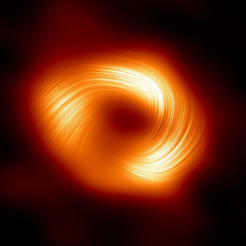 Black holes could have planets: Striated orange spiral with brighter areas and a black center.